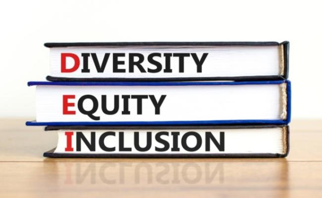 Diversity Equity Inclusion written on spine of three stacked books