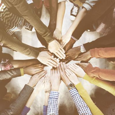 Diverse group of people with hands in a circle