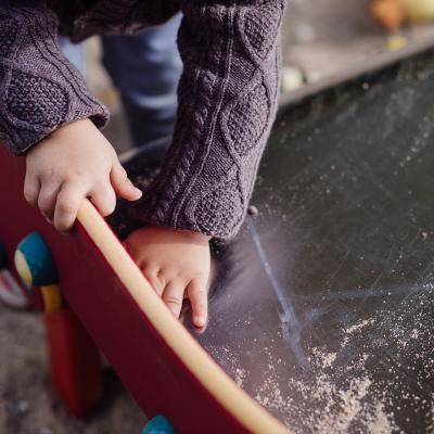 close up of a child playing outside in a sandbox