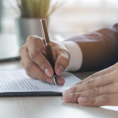 Image of hands, signing a letter