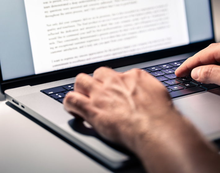 Stock Photo of a person writing a letter with a laptop.