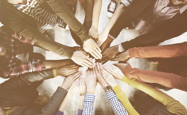 Diverse group of people with hands in a circle