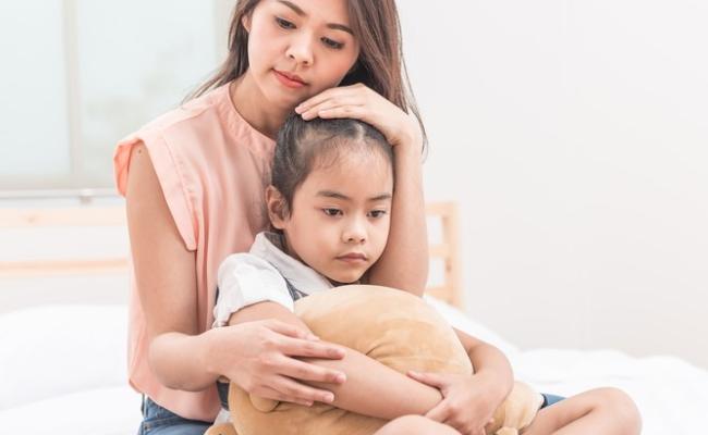 An asian mother consoling her sad daughter